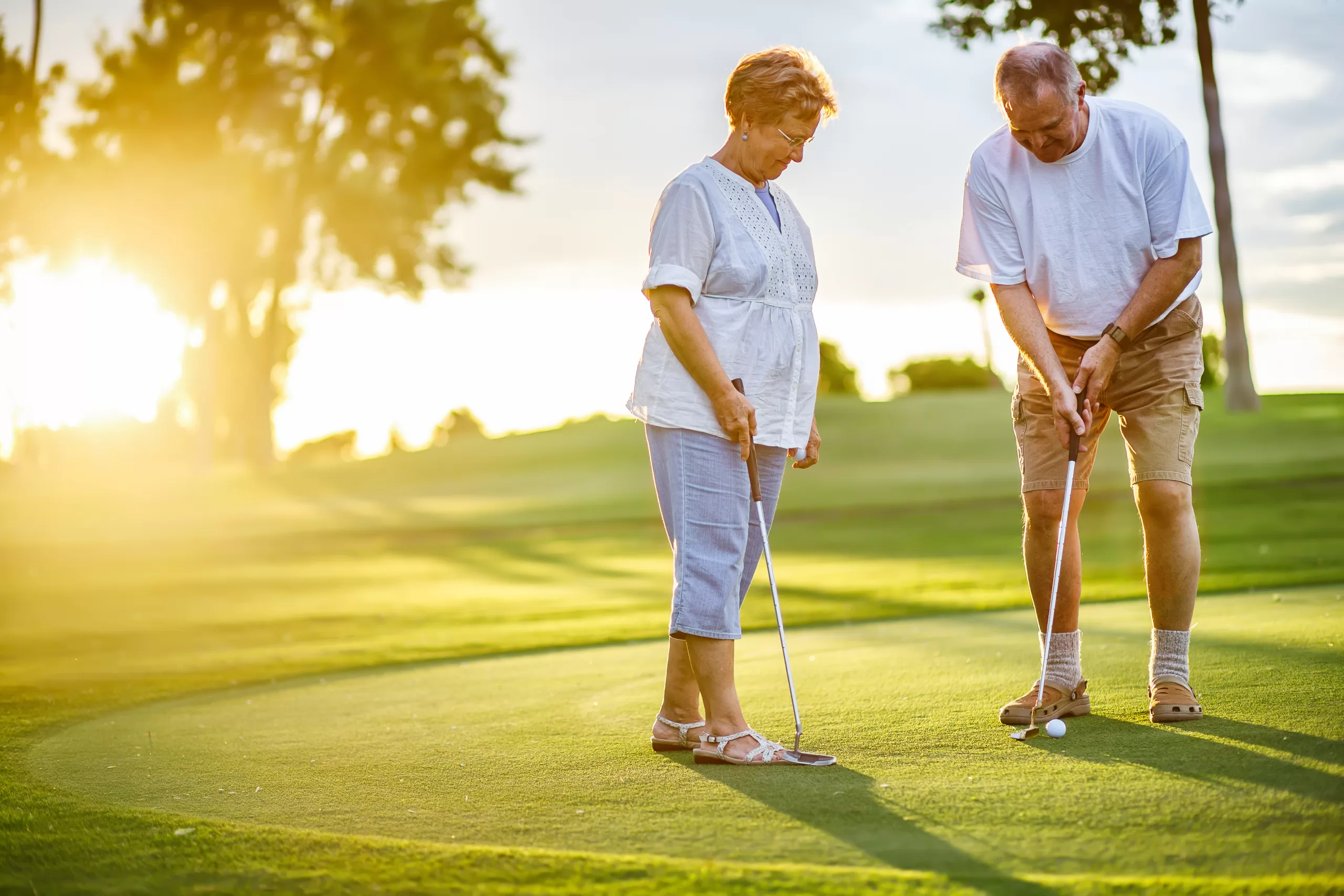 active senior lifestyle, elderly couple playing golf together at